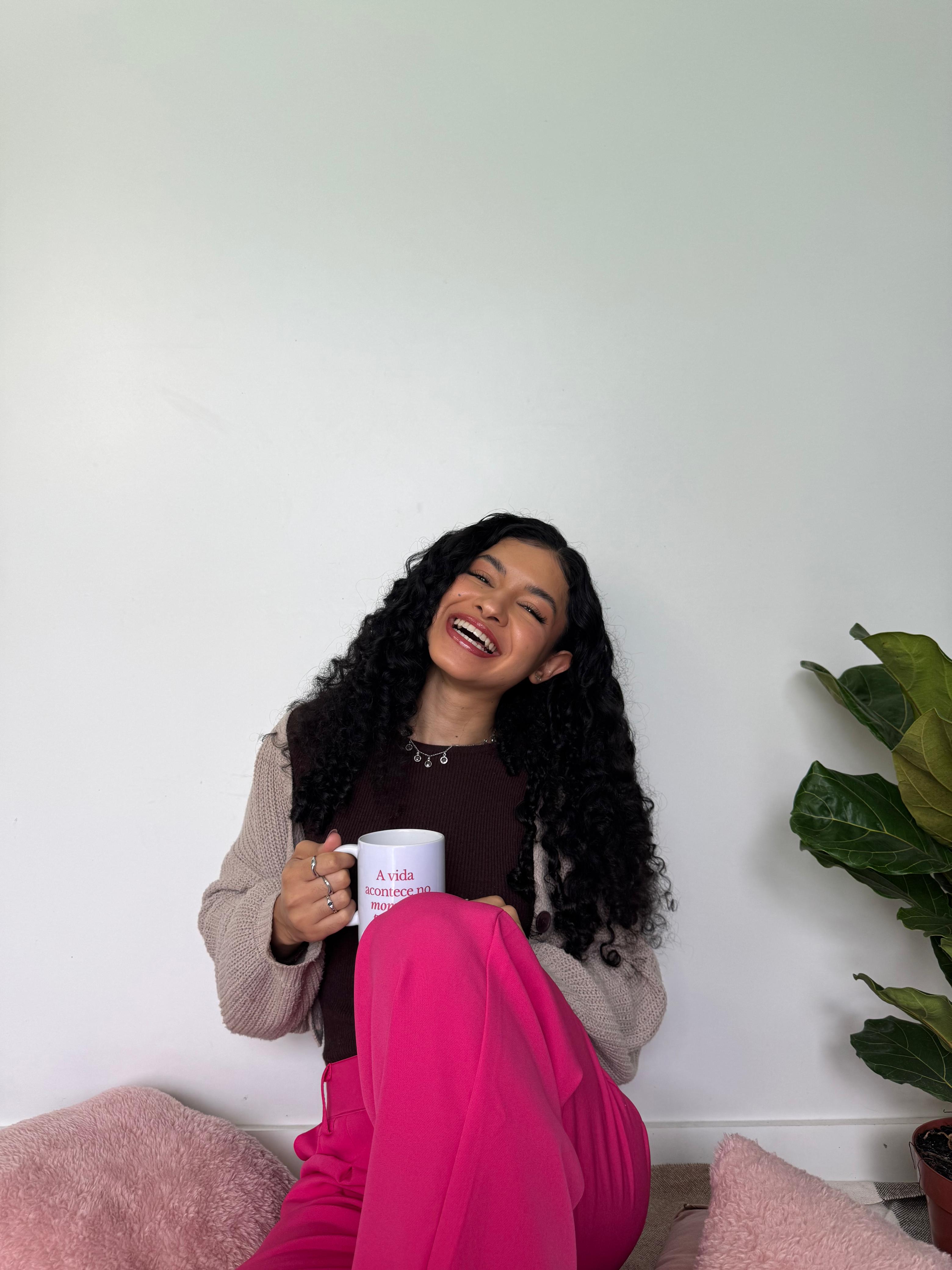 Alana Brígida sorrindo com uma caneca na seção Sobre mim.