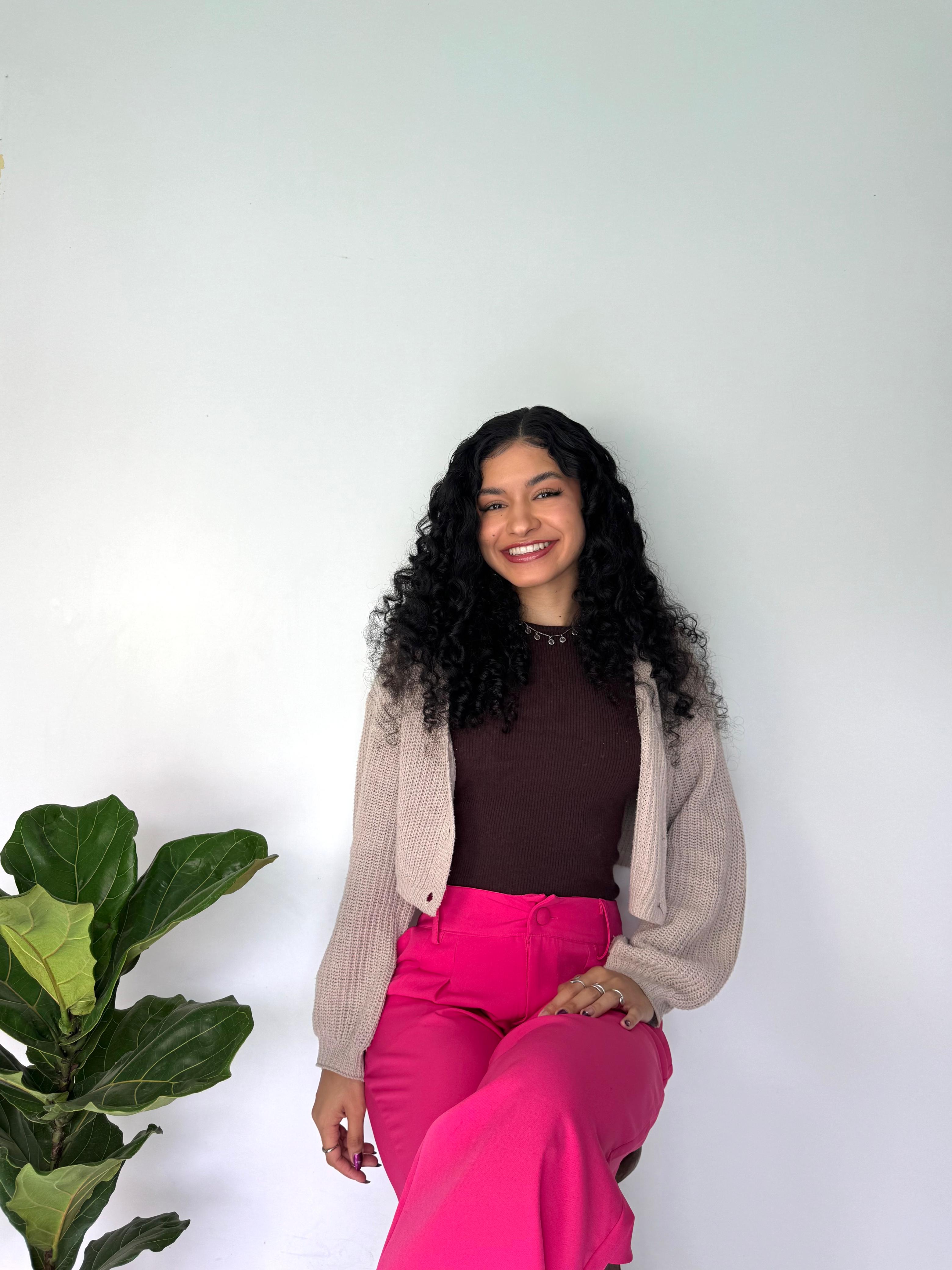 Alana Brígida sorrindo em retrato de apresentação.