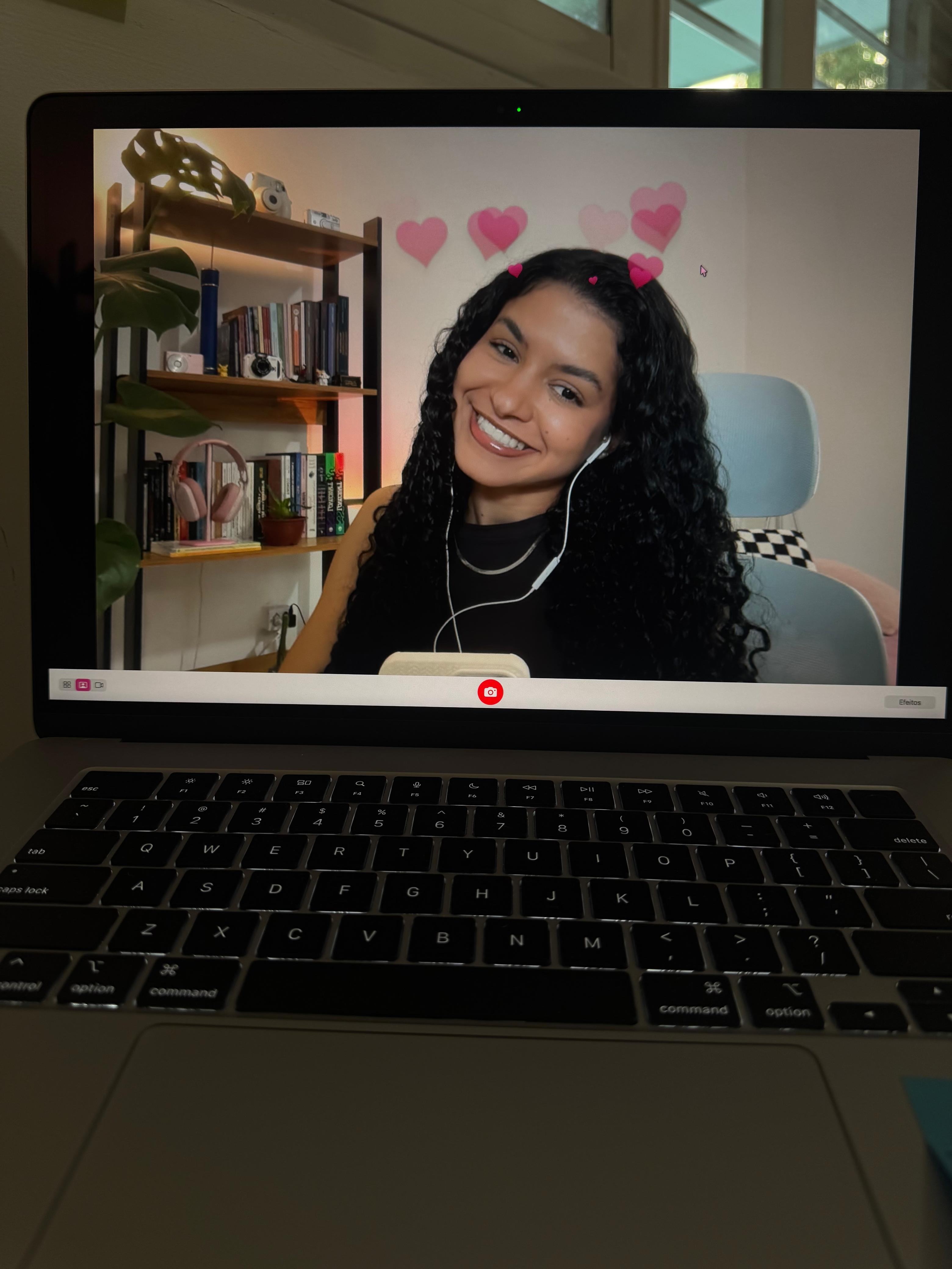 Alana Brígida sorrindo em uma chamada de vídeo.